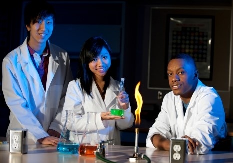 Diverse secondary science students with chemistry apparatus