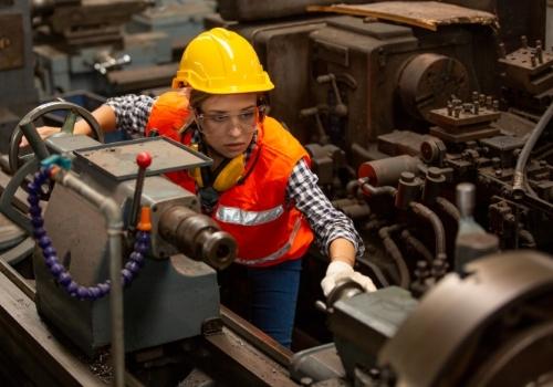 Female engineer inspecting factory equipment